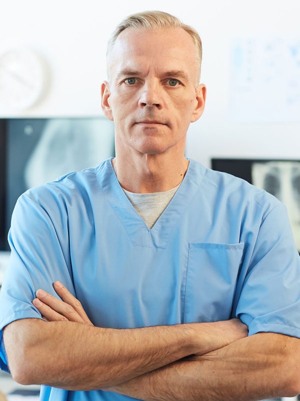 portrait-of-mature-doctor-posing-in-clinic-K9PMYGL